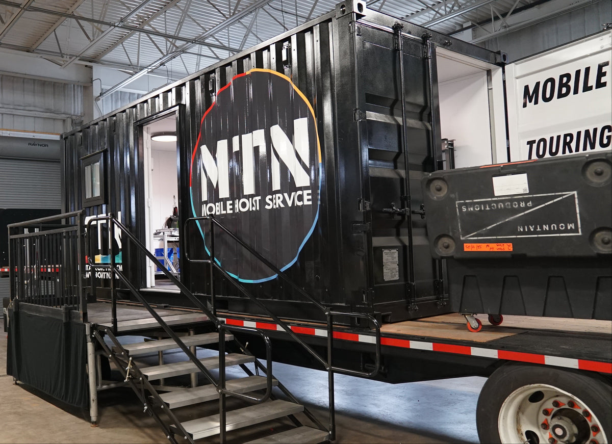 Black mobile unit service truck with visible branding inside a warehouse.