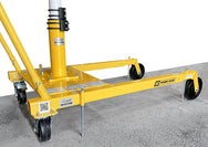 An OZ Lifting Products yellow Davit crane mobile wheel base showing the floor-anchor kit pins extended into a concrete floor for stability, isolated on a white background. - imagen 2